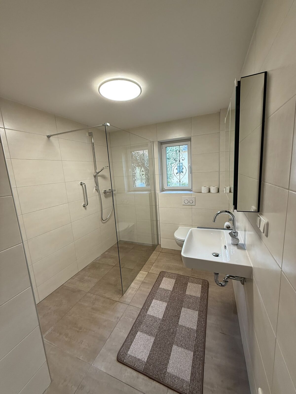 Barrierefreies Bad mit bodengleicher Dusche und Haltegriff