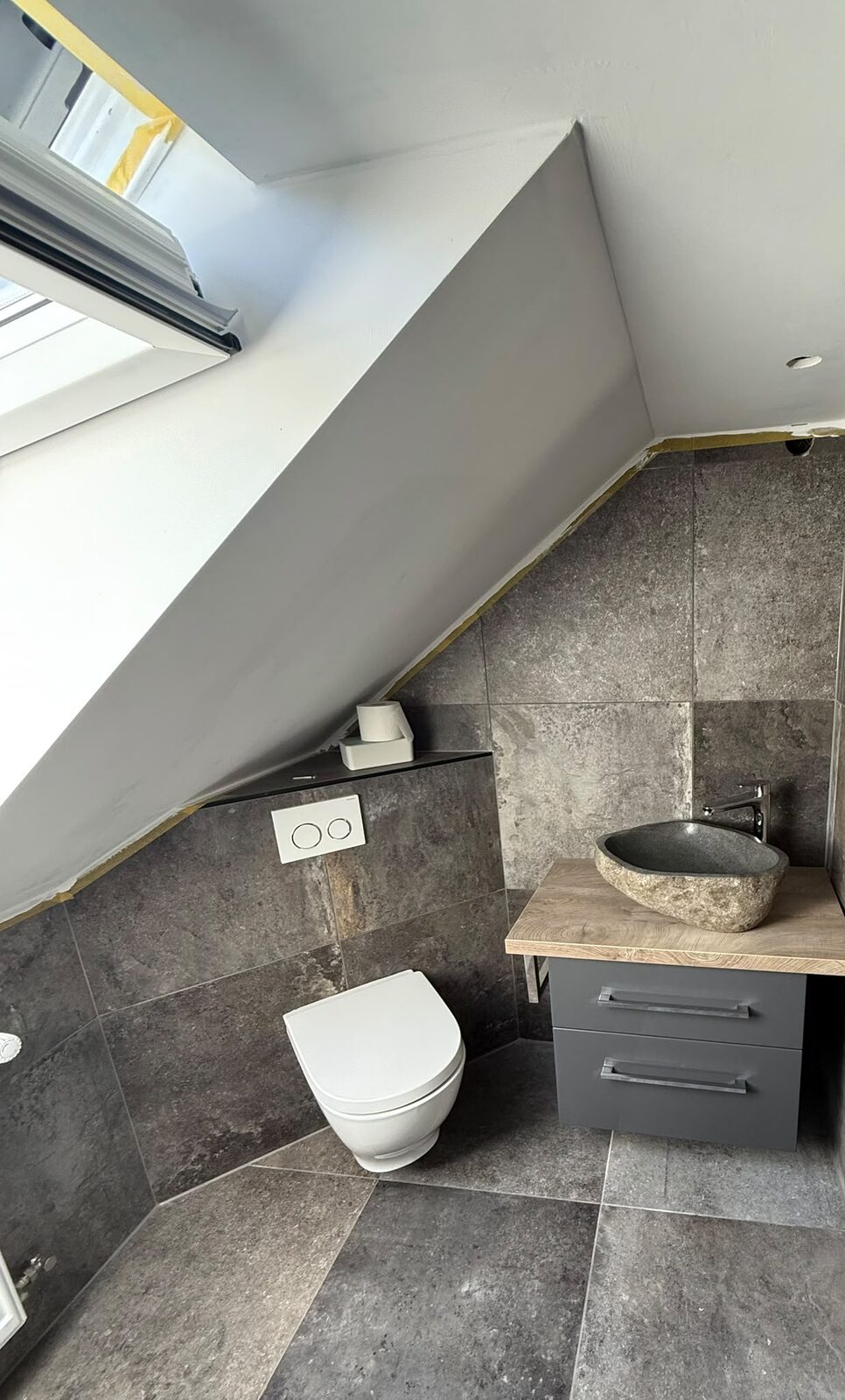 Dachgeschossbad mit WC und Waschtisch in Steinoptik
